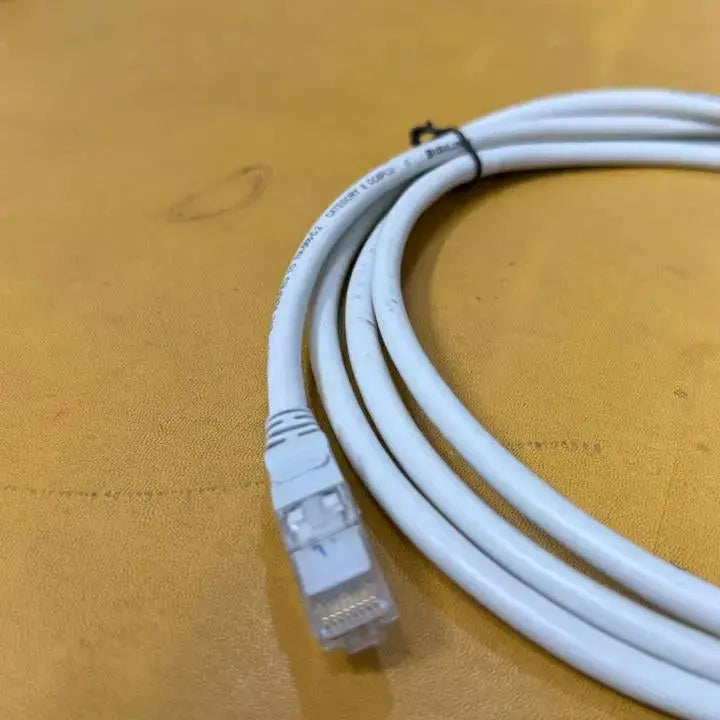 White Ethernet cable on a wooden surface